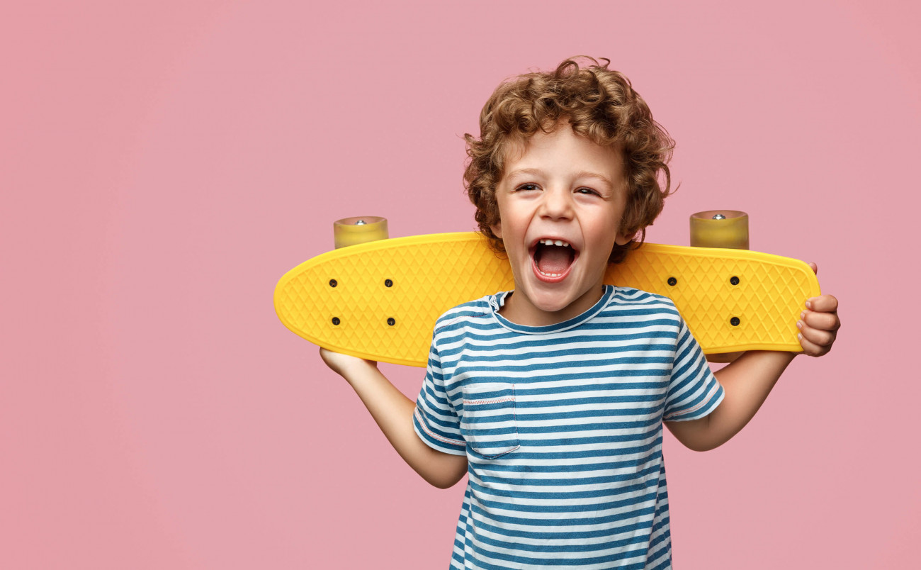 Little boy with big smile and a skateboard