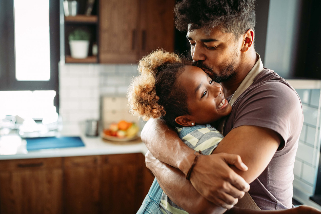 Dad and daughter hugging in the kitchen