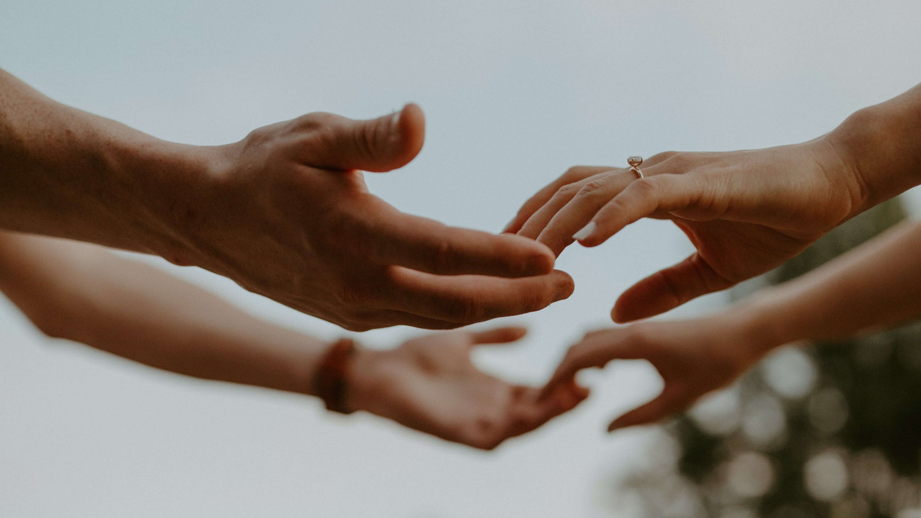 Two sets of hands reaching for each other